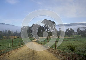 Rural country road Qld Australia.  Unsealed road fog in distance