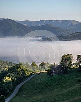 Rural countryside landscape in the Transylvania region of Romania, mist-covered hills