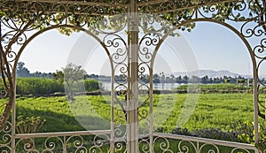 Rural countryside view of a river in summer through trellis