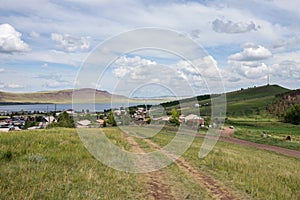 The rural dirt road leads to the settlement Lake Uchum on the shore of the lake.