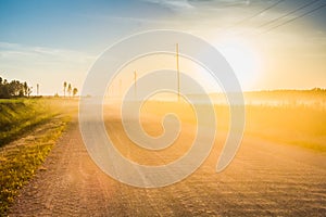 Rural dirt road in the light of the sunset, landscape