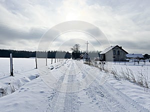 Rural dirt road among trees in winter conditions