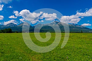 Rural fields near Tatra Mountains in summer time. beautiful panorama of agricultural area. gorgeous mountain ridge with high rocky