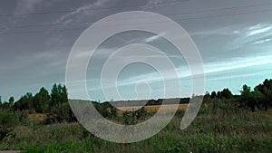 Rural fields, road and forest. The car rides along the fields. The view from the car