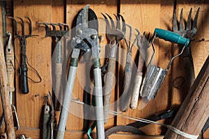 Rural garden tools on the wall of a wooden shed