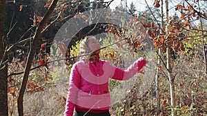 Rural girl enjoys leaf fall in the autumn forest