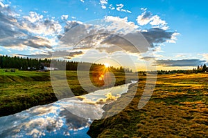 Rural grassland landscape in sunny spring evening. Sunset in Jizerka village with Jizerka river, Jizera Mountains, Czech