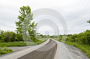 Rural gravel country road on a cloudy day landscape