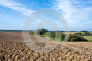 Rural, hilly landscape with freshly ploughed field in autumn. Fresh plowed ararian field
