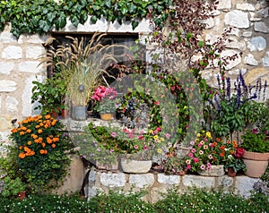 Rural house decorated with flowers in pots, France