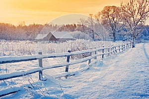 Rural house with a fence in winter