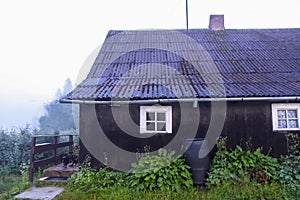 Rural house in a fog in summer evening