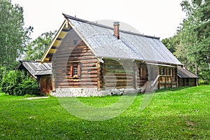 Rural house with green lawn on front yard in forest among trees