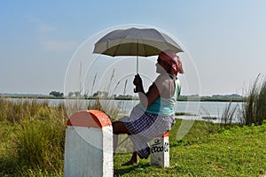 Rural Indian cowherd man keep an eye on his cattle from road side