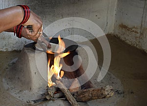 Woman preparing chapati in traditional way on a wood fired oven photo