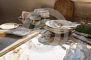 Rural kitchen interior. Cups and plates on the table. Rustic kithenware. Vinage kitchen utensil.