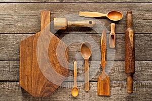 Rural kitchen utensils on vintage planked wood table from above. Rustic background with tools