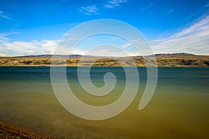 Rural lake landscape with reeds, wildlife and with blue skies and clouds