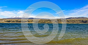 Rural lake landscape with reeds, wildlife and with blue skies and clouds