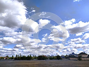 Rural landscape against the background of a contrasting sky with clouds