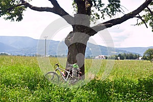 Rural landscape cyclist rest under a tree in Moravian-Silesian region against the background of mountains Western Carpathians