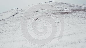 Rural landscape of fields and meadows covered with snow in winter, view from an FPV drone. Drone racing, fun modern