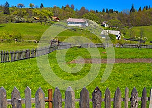 Rural landscape of fields separated by wood fences at spring in Maramures Romania.