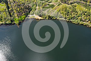 Rural landscape with green forest near lake on summer day. aerial panoramic view