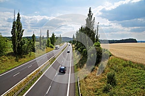 The rural landscape with a highway leading poplar alley, the highway ride three cars and a truck