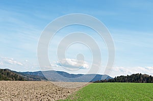 Rural landscape. Meadow and plowed field, against the background of mountains. A natural concept. Economic work