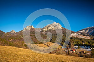 Rural landscape with mountain peaks on background in early sprin