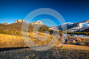 Rural landscape with mountain peaks on background in early sprin