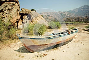 Rural landscape with old fishing boat on the dry land of beach, lake Bafa, rural Turkey.