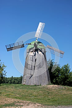 Rural landscape with Old wooden windmill on the blue sky background in summer day.