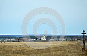 Rural landscape. Orthodox wooden cross beside the road. Church. Spring.