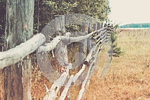 Rural landscape with rough fence, forest and meadow