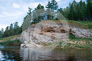 Rural landscape with stone ridge and river at summer cloudy day