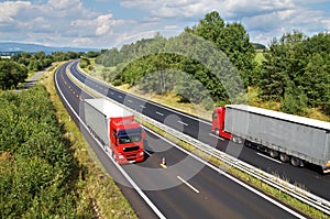 Rural landscape with trees lined the highway, the highway ride two red trucks