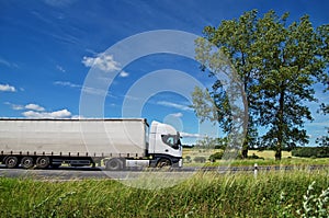 Rural landscape with white truck on the road