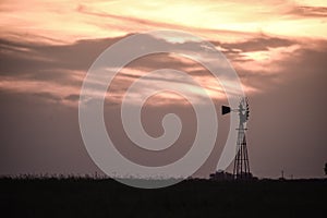 Rural landscape with windmill at sunset