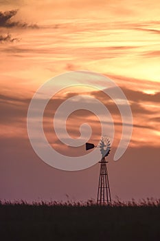 Rural landscape with windmill at sunset,