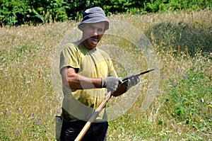 Rural man using scythe