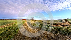 Rural Maryland Farm Landscape with long Dirt Road leading to a Red Barn