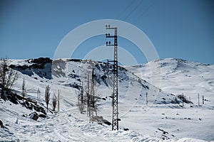 Electricity poles and winter mountain road photo