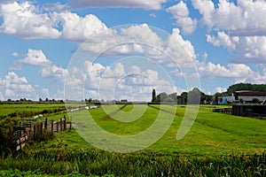 A rural Netherland`s landscape with green fields and meadow as far as the eye can see.