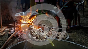 Rural people cooking large meals with wood and basic pottery