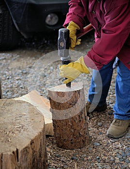 Rural person splitting wood for winter