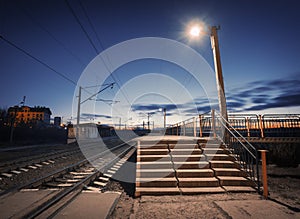 Rural railway station at night with blue sky. Railroad