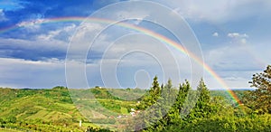 Rural rainbow landscape, view of green meadows and hills