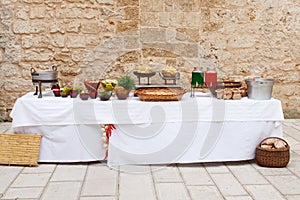 Rural reception table served with various food and drinks for birthday party or wedding. Catering concept